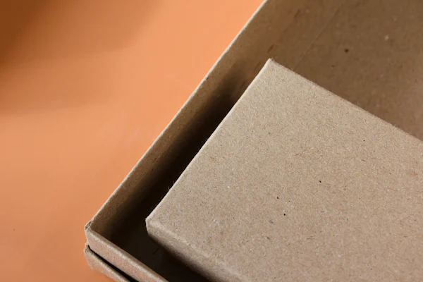 A greyboard box with its lid half open against an orange background